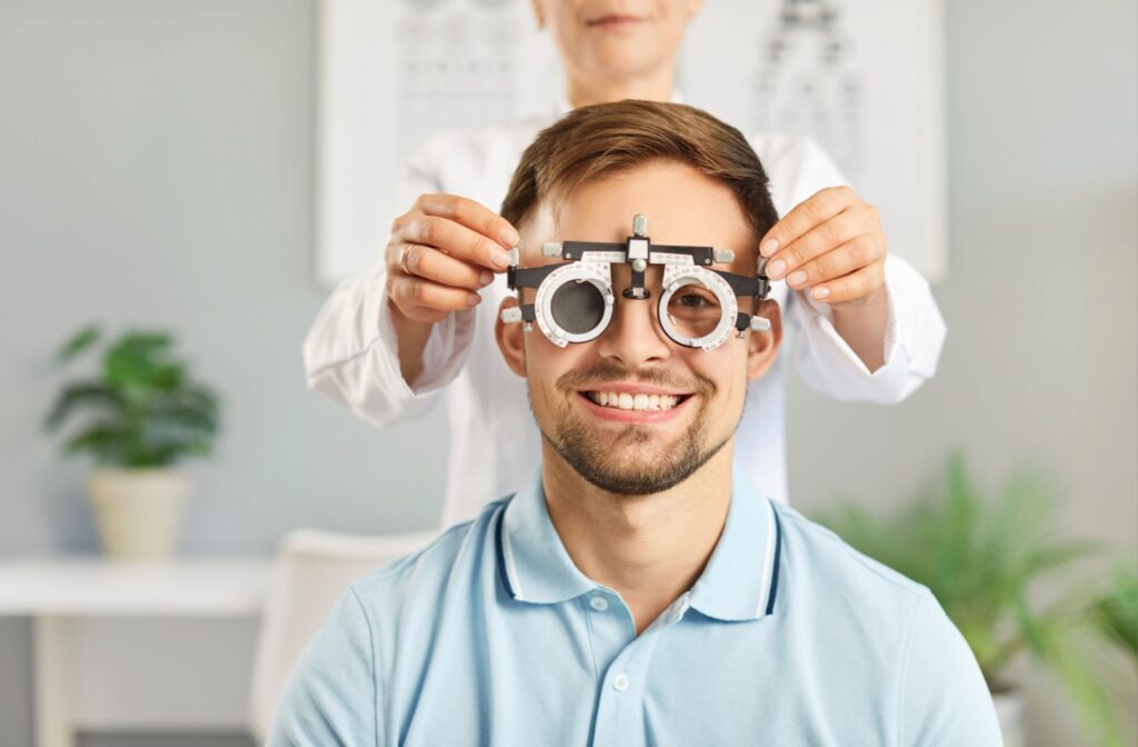 Smiling patient looking at the camera with an eye examination device positioned over their eyes.